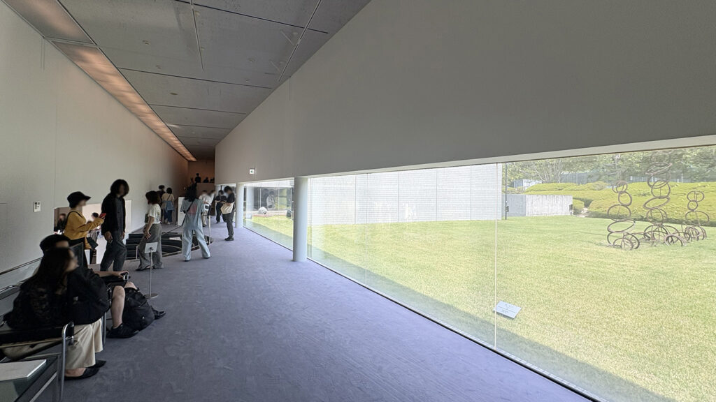 資料展示室と美術展示室の間のロビー。ミラーガラスは屋内から見ると透明に見え、開放的な空間に感じられる