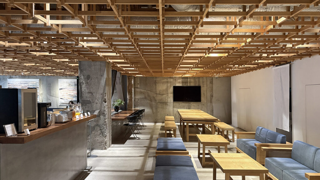 ホテルのラウンジ。エントランスやカフェ&バーと一体的な空間に設けられており、木格子の天井内には空調ダクトが仕込まれているのが見える。後述するように、家具もオリジナルのデザイン